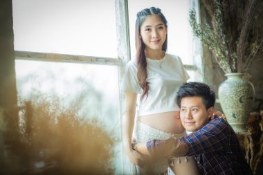 Çok mutlu güzel genç adam ve kadın hamile karnına.