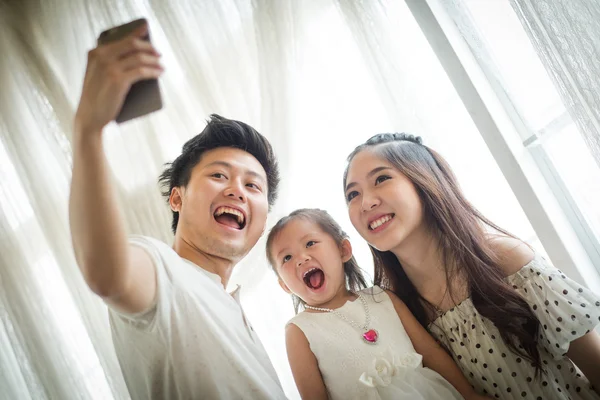 Familia con niña en el parque tomando selfie por teléfono móvil — Foto de Stock
