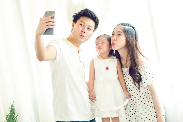 Famille avec petite fille dans le parc prendre selfie par téléphone mobile . — Photo