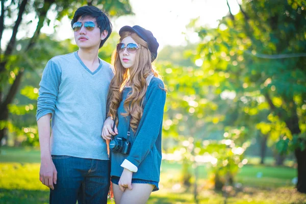 Men and women wearing sunglasses Park in the shade — Stock Photo, Image