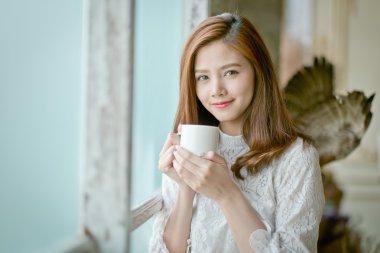 Kupası tutan muhteşem genç esmer kadın portresi.