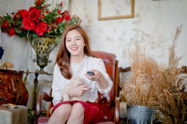 Eğlenceli izlerken bir uzaktan kumanda tutan genç kız film .