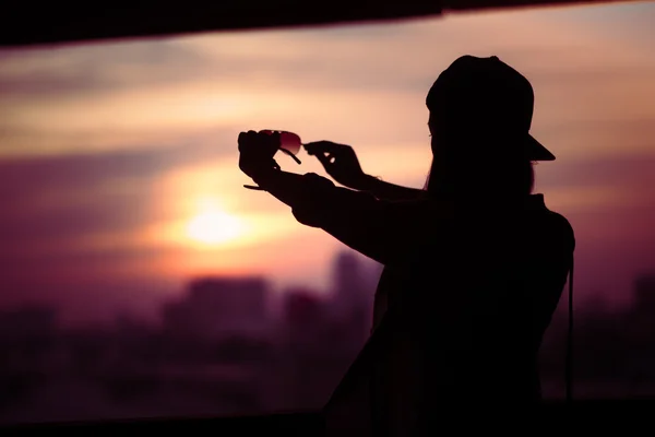 Girl shooting backlit Looking through solar glasses