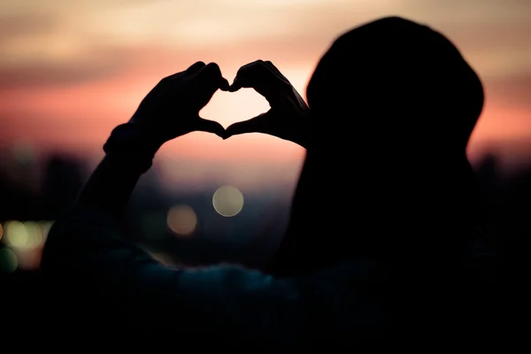 Dziewczyna fotografowania podświetlany ręcznie wykonane w kształcie serca, strzelnica backl — Zdjęcie stockowe