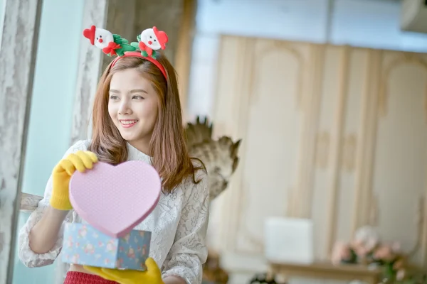 Little girl with winter clothes holding  gift box — Stock Photo, Image