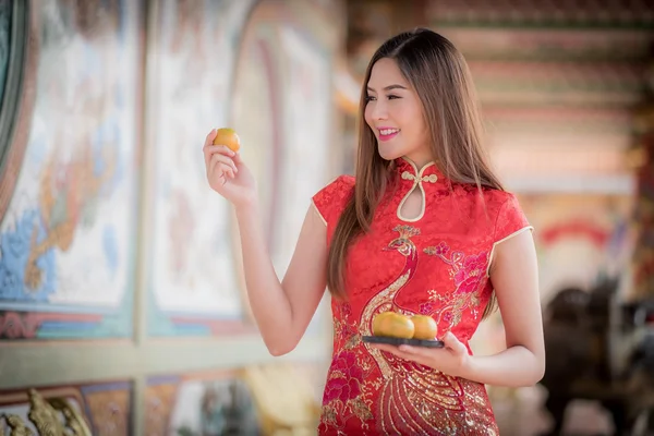 Азиатская китаянка в традиционном китайском держит апельсин па — стоковое фото