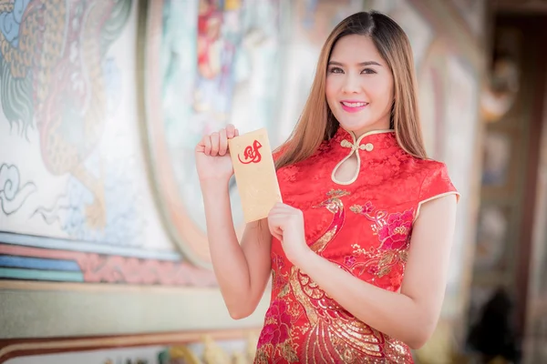 A mulher asiática em vestido chinês segurando couplet 'Lucrativ — Fotografia de Stock