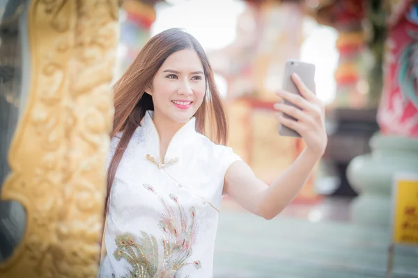 Asiatische Chinesin in traditionellem Chinesisch und Telefon halten — Stockfoto