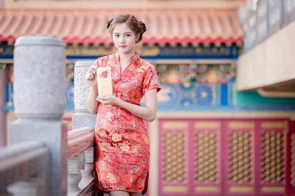 A mulher asiática em vestido chinês segurando couplet 'Lucrativ — Fotografia de Stock
