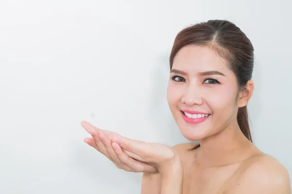 Beautiful young woman with healthy clean skin presenting somethi — Stock Photo, Image