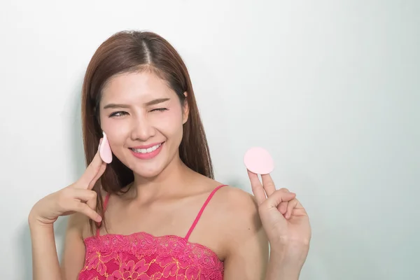 Young woman applying foundation on face with powder puff — Stock Photo, Image