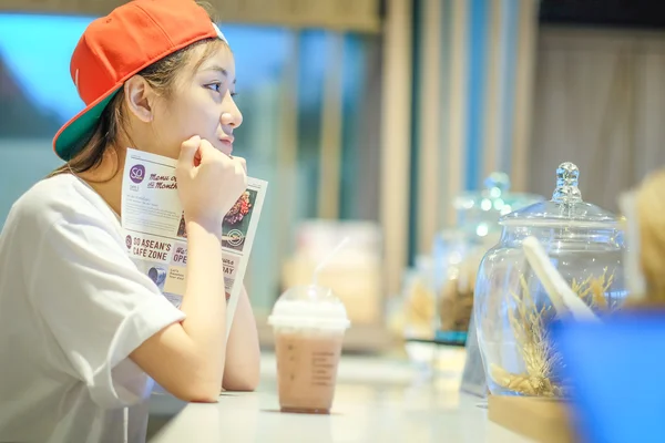 Молода жінка п'є льодову каву в ресторані — стокове фото