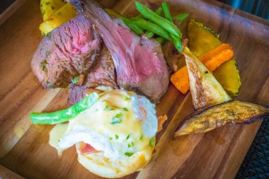 Bir tabak yumurta benedict ile kuzu biftek 