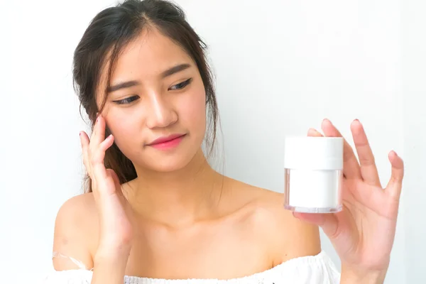 Skincare products, Portrait of Beautiful Young Woman looking at Stock Photo