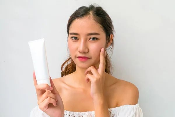 Mujer asiática usando un producto natural para el cuidado de la piel, crema hidratante o lo — Foto de Stock