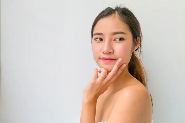 Mooie vrouw met een gezonde schone huid presenteren iets op — Stockfoto