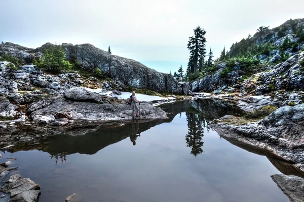 Mulher por lago alpino e reflexão . — Fotografia de Stock