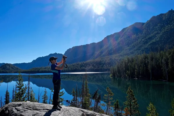 Fotografin am Alpensee mit Spiegelung im ruhigen Wasser. — Stockfoto