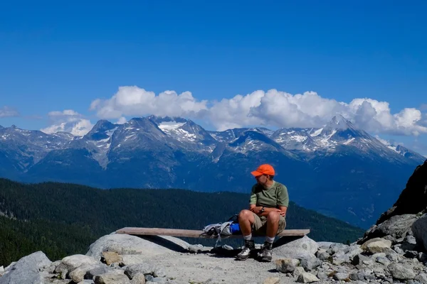 A hegy tetején ül az ember természetjáró. — Stock Fotó