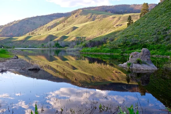 Hills reflektion i lugna vatten. — Stockfoto