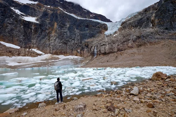 Ecoloog werkzaam bij een moraine lake met ijsbergen. — Stockfoto
