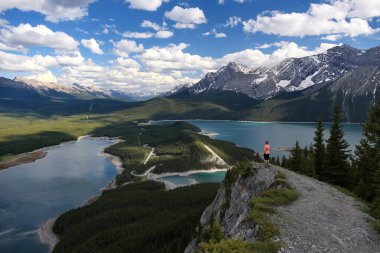 Karlı dağların yanındaki turkuaz gölün üzerinde bir kadın. Kananaskis gölleri. Kanada Kayalıkları. Alberta. Kanada 