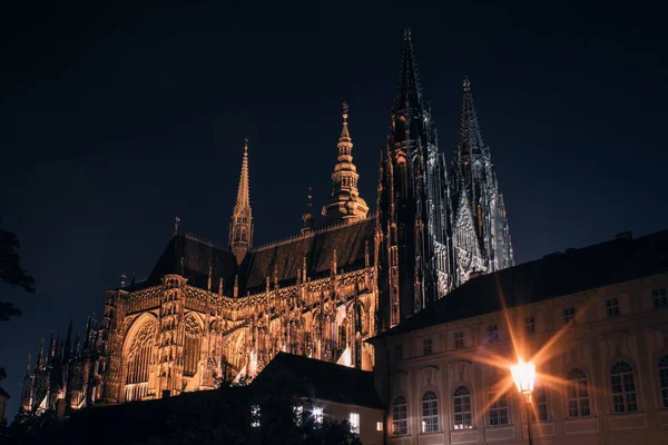 Çek Cumhuriyeti Prag Şatosu 'ndaki St. Vitus Katedrali' nin gece manzarası karanlık gece gökyüzüne karşı altın ışıklarla aydınlandı..