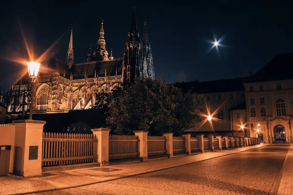 Çek Cumhuriyeti Prag Şatosu 'ndaki St. Vitus Katedrali' nin gece manzarası ay ışığı altında sıcak sokak lambalarıyla aydınlatılıyor..
