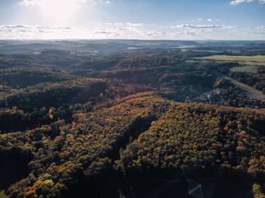 Günbatımında, sonbahar ormanlarının ve kırsal manzaranın havadan görünüşü, renkli ağaçları, yuvarlanan tepeleri ve huzurlu doğa manzaralarını gösteriyor..