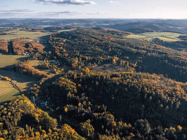 Çek kırsalındaki kayan tepelerin ve sonbahar ormanlarının havadan görünüşü... altın saat manzarası... renkli ağaçlar, tarlalar ve uzak sıradağlar....