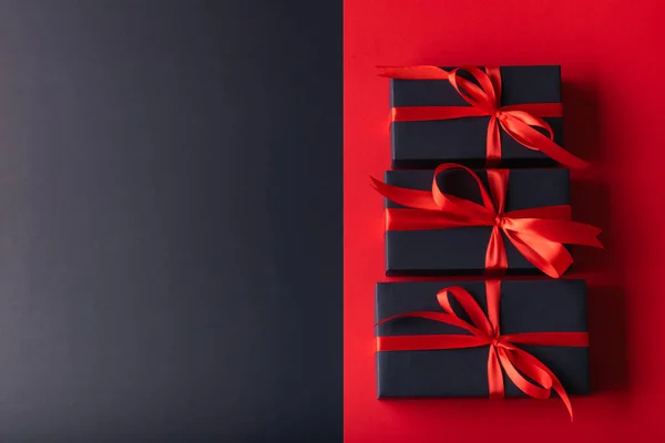 3 black box with red ribbon on half black color background and half red color background. 11.11 single day, Monday, Friday sale concept