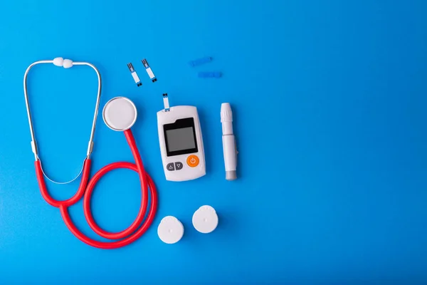 Dünya Diyabet Günü, mavi zemin üzerinde Ücretsiz Glikoz Monitörleri, kırmızı steteskop mavi üzerine mavi üzerine sağlık ve tıbbi konsept