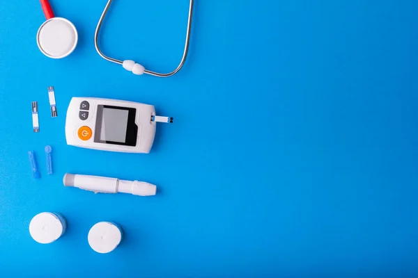 Dünya Diyabet Günü, mavi zemin üzerinde Ücretsiz Glikoz Monitörleri, kırmızı steteskop mavi üzerine mavi üzerine sağlık ve tıbbi konsept