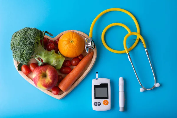 Diyabet monitörü, diyabetik ölçüm. Diyabet günü konsepti ve beslenme uzmanının kalp kaplarında temiz meyveler