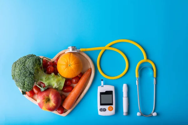 糖尿病モニター糖尿病測定 栄養士の心臓皿のきれいな果物と世界糖尿病の日の概念 黄色の聴診器は心臓プレート上の果物をチェック — ストック写真