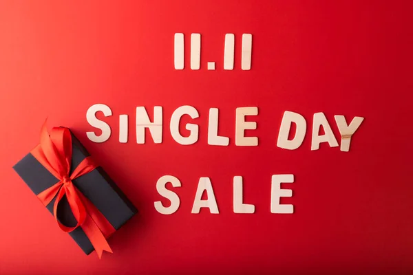 11.11 Single day sale. Small cart with 11.11 single\'s day sale text was made from wood on red color background. Top view