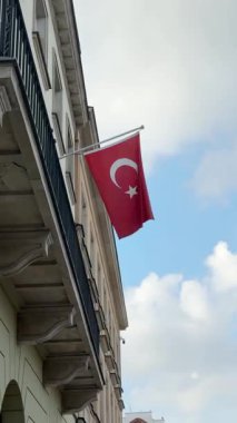 Türk bayrağı rüzgarda dalgalanıyor. Türkiye 'nin siyasi sembolü eski binaya, sokaktan manzaraya sabitlenmiş.