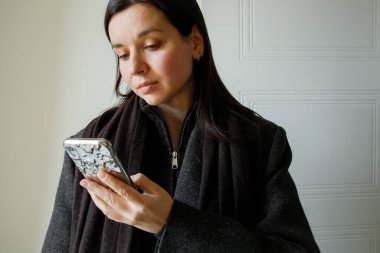 Genç bayan esmer cep telefonu kullanıyor. Yakın plan portre. Modern sensör akıllı telefon teknolojisi, ekran süresi, cihazlarla rahat yaşam