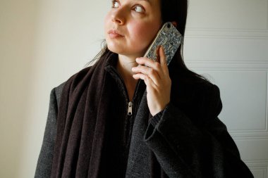 Genç bayan esmer, akıllı telefon kullanarak telefon görüşmesi yapıyor. Yakın plan portre.