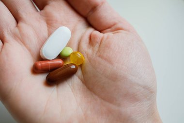 Kadınların elinde farklı ilaç ve kapsüller var. Evde tıbbi ilaçla tedavi görüyor. Günlük dozda vitamin ve takviye, biyohack.