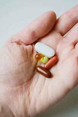 Renkli haplar, haplar, kapsüller kadın elinin altında. Sağlık ve İlaç Hizmetleri.