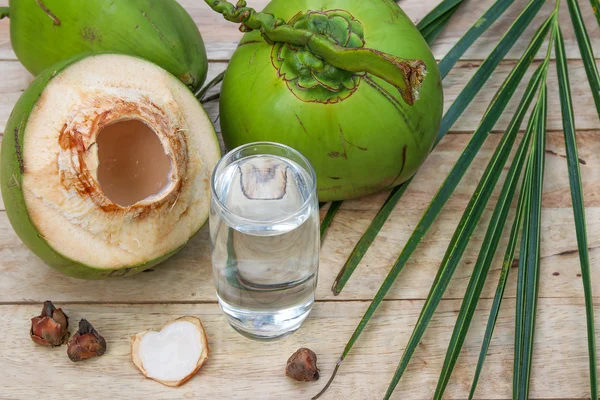 Eau de coco fraîche Boisson en verre avec feuille de noix de coco sur fond en bois — Photo