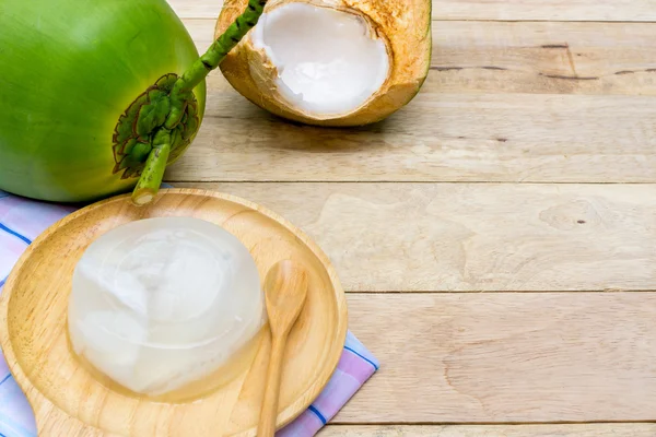 Hindistan cevizi jöle ve tahta kaşık ahşap arka plan üzerinde