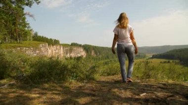 Dağın tepesinde spor yapan bir kız.