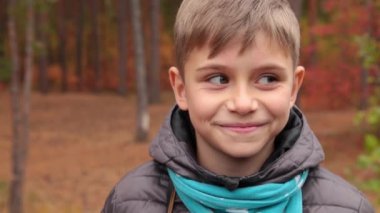 Çocuk gülümser ve bir film kamerasıyla fotoğraf çeker..