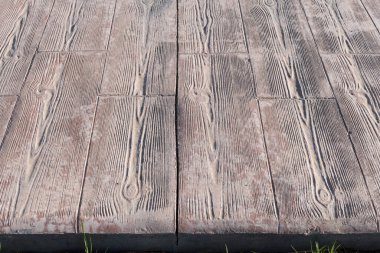 Damgalanmış beton kaldırım. Ortadaki detay genişletme eklemleri ahşap döşeme desenleri, döşeme döşemesi dış döşeme, ahşap çizgilerle dekoratif beton döşeme dokusu.