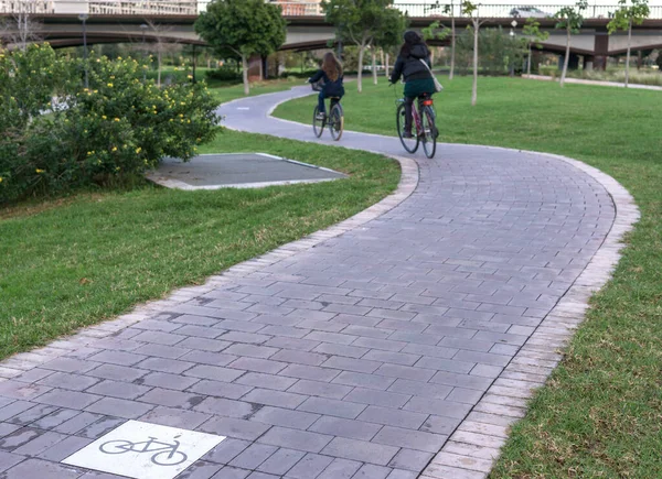 Cycleway sinalizou uma ciclovia terrestre com dois ciclistas circulando. ciclovia entre árvores Jardin Turia em Valência Espanha — Fotografia de Stock