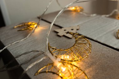 Köknar çelenginin yanındaki paketlenmiş hediye kutusu, gün ışığında pencerenin yanında sıcak ışıkla parlayan çelenkle kaplanmış. Yeni yıl hediyesi. Ay gibi çelenk. Noel hediyesi. Seçici ve yumuşak odak