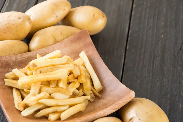 Batatas fritas em fundo de madeira — Fotografia de Stock