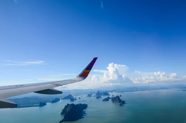 Island and sea with plane wing — Stock Photo, Image
